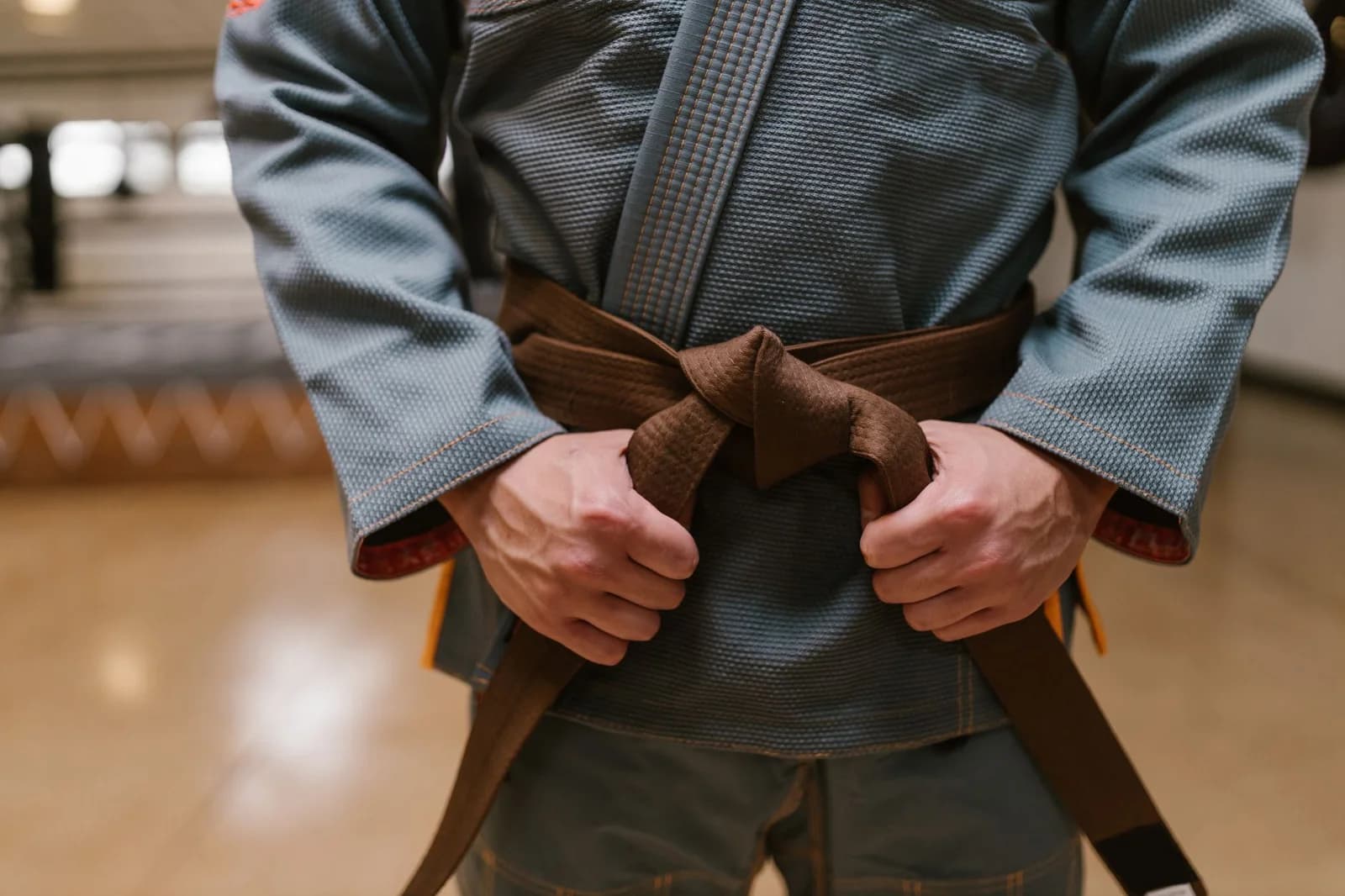 Faixa-marrom de Jiu-Jitsu amarrando a faixa sobre o kimono. Foto de RDNE Stock project via Pexels.